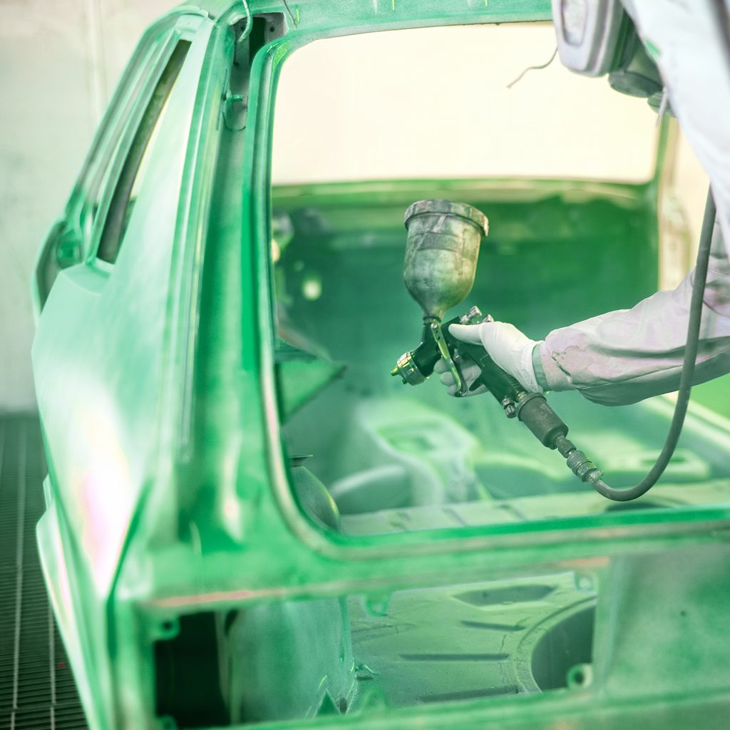 Lackierer trägt Speziallack im Innenraum einer Fahrzeugkarosserie in Steyr auf